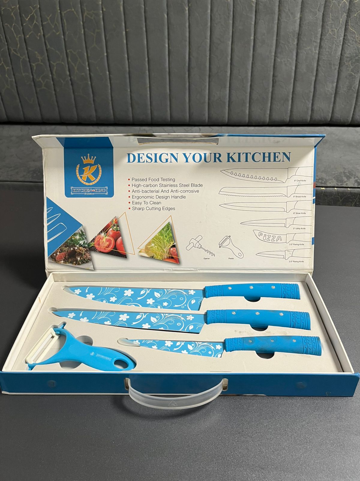 Set of blue knives in a box with 'Design Your Kitchen' branding on a gray background